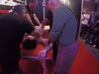 A group of people massage this young and tattoed girlfriend at the same time in public